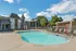 Community pool with sun chairs in front of apartments