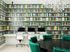1810 The Social, interior, computer room, gray, white, green, black, yellow book wall paper, three Mac computers, white desk and chairs, large black table with green chairs