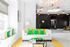 1810 The Social, interior, spacious seating area, chandelier, decor is white with green and yellow accents, large sofas, large window, reception area, black wall, black sign, black desk