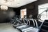 1810 The Social, interior, fitness center, black walls, sign 'The Jim', chandeliers, treadmills, elliptical, windows, stair climber