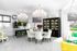 1810 The Social, interior, library, white table ad chairs, white walls, white floor, accents of yellow, green and black