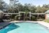 1810 The Social, exterior, sparkling blue swimming pool, lounge chairs, pergolas, foliage and trees