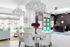 1810 The Social, interior, main lobby, white table ad chairs, white walls, white floor, accents of yellow, green and black, three large sofas, main reception, black wall, black desk, black sign, green doors,