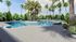 1800 The Ivy, exterior, sparkling blue swimming pool, sign 'The Swim Club', palm trees, trees, lounge chairs, building exterior