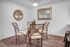 Stylish dining area with a glass table and wooden chairs on hardwood flooring. | Wingpointe | Apartments in Clearfield, Utah