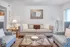 Elegant living room with stylish accents including a beige sofa, patterned armchairs, and a decorative mirror. | Wingpointe | Apartments in Clearfield, Utah