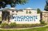 Wingpointe Apartments entrance sign with greenery and residential buildings in the background. | Wingpointe | Apartments in Clearfield, Utah