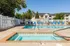 Inviting swimming pool with lounge chairs and leafy trees in a serene apartment complex. | Wingpointe | Apartments in Clearfield, Utah
