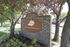 Welcoming stone entrance sign for Triton Heights surrounded by lush greenery and trees.
