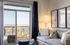 Bright and modern living room with a cozy grey sofa, stylish decor, and expansive city view from the balcony. | Point of View | Apartments in Draper, Utah