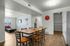 Inviting open-concept dining area with modern kitchen features, wood flooring, and natural light-infused living room.