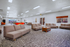 Spacious recreational lounge featuring modern sofas, a vibrant pool table, and ample lighting, perfect for social gatherings and relaxation.