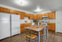 Inviting kitchen with warm wooden cabinetry, sleek appliances, and a cozy dining area perfect for family gatherings.