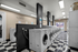 Modern and spacious laundry room featuring state-of-the-art washing machines in a sleek, well-lit environment with stylish black and white flooring.