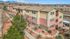 Charming apartment complex nestled against a scenic mountain backdrop, featuring lush landscaping and a modern exterior design.
