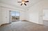 Bright and spacious apartment room with elegant fan, plush carpeting, and sliding glass doors opening to a scenic balcony view. | Triton Terrace | Apartments Draper, Utah