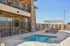 Luxurious apartment complex featuring a chic stone facade, inviting swimming pool, and stylish outdoor seating area with sun loungers for relaxation. | Triton Terrace | Apartments Draper, Utah