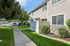 Charming apartment exterior with lush green landscaping and a private fenced patio entrance, offering serene living in a well-maintained community. | Windmill Cove | Apartments in Sandy, Utah