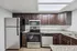 Modern kitchen with sleek stainless steel appliances, rich dark wood cabinets, and elegant granite countertops. | Windmill Cove | Apartments in Sandy, Utah