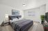 Elegant bedroom with cozy king-sized bed, stylish decor, and abundant natural light. | Windmill Cove | Apartments in Sandy, Utah