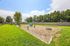 Inviting outdoor playground set in lush green surroundings, perfect for families seeking a vibrant community ambiance. | Windmill Cove | Apartments in Sandy, Utah