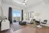 Modern living room with sleek decor, cozy seating area, and bright natural light through a large balcony window offering stunning views.| Point of View | Apartments in Draper, Utah