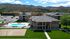 Scenic student community with modern buildings, a refreshing pool, and sports court set against stunning mountain views.