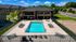Inviting apartment complex with a sparkling outdoor pool, surrounded by stylish lounge chairs and vibrant greenery.