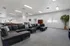 Spacious and modern lounge area featuring luxurious black leather sofas, chic decor, ample natural light, and stylish entertainment space.