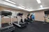 Modern fitness center with state-of-the-art treadmills, elliptical machines, and a stationary bike in a well-lit room.