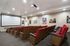 Luxurious private theater room with plush red seating, large screen, and vibrant movie posters, offering an immersive cinematic experience.