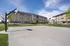 Charming apartment complex with a well-maintained outdoor basketball court under a clear blue sky, perfect for active living.