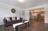 Inviting open-plan apartment featuring a cozy living room with a plush sofa, elegant coffee table, and a stylish kitchen with dining area, adorned with warm wooden flooring.
