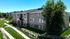 Modern apartment building surrounded by lush greenery and well-manicured lawns, showcasing a serene residential environment.