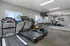 Inviting fitness center featuring modern treadmills, free weights, and exercise equipment with ample natural light.