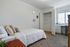 Bright and cozy bedroom with plush carpeting, stylish decor, and ample closet space, perfect for tranquility and comfort.