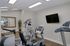 Modern apartment gym with state-of-the-art exercise machines, sleek design, and ambient lighting.