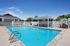 Inviting outdoor pool area with lounge chairs, pergola, and vibrant patio seating perfect for relaxation and entertainment.