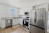 Bright contemporary kitchen featuring sleek stainless steel appliances, chic white cabinetry, and elegant granite countertops.