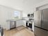 Modern kitchen with sleek stainless steel appliances, bright white cabinets, and elegant granite countertops, filled with natural light.