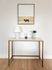 Modern decor setup featuring a sleek marble console table with gold accents, a stylish lamp, and a vase of fresh flowers, complemented by a framed bison artwork on the wall.