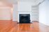 Living room with hardwood floors, built in bookshelf and wood burning fireplace