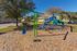 Creekside Park Apartments, exterior, play ground equipment, swing set, blue and green, trees, grass, buildings,