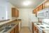 Creekside Park Apartments, interior, kitchen, wood cabinets, double sink, white appliances, stove/oven, microwave, refrigerator, dishwasher, doorway