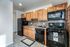 Kitchen fully updated with black appliances (gas range, dishwasher, microwave, fridge)