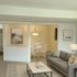 Living room with sofa and table. Open dining room with wall art.