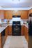 Kitchen with black appliances and oak cabinetry