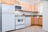 Sunny kitchen. White appliances, maple cabinets.