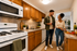 Park Crescent Apartments kitchen with wood cabinets, breakfast counter, and white appliances