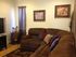 A brown wrap-around couch in front of a TV. | Rental Houses near Schriever SFB, Colorado Springs CO